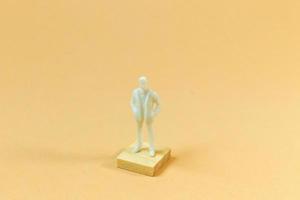 white  figure miniature on orange pastel for business content. photo