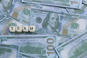 Team word on wood brick  background banknote. photo