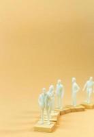 white  figure miniature on orange pastel for business content. photo