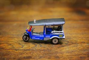 tuk tuk taxi  toy  on wood table close up image. photo