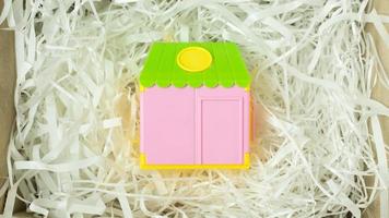 Toy home on Cushioning paper in box for home business content. photo