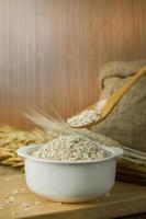 The Healthy breakfast cereal oat flakes in bowl on wooden table. photo