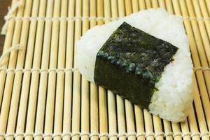 The Japanese food Onigiri  white rice formed into triangular or cylindrical shapes and often wrapped in nori. photo