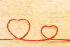 Red rope heart on wood plate valentine content. photo