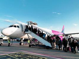 People are boarding a Wizz Air plane. Photo taken from the plane. October 2019. Warsaw. Poland