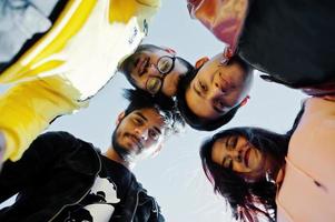 Group of four asian people friends stand on and looking at camera down. photo