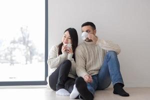 multiethnic couple enjoying morning coffee by the window photo