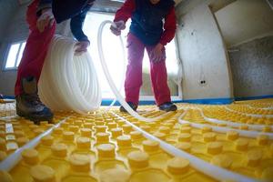 workers installing underfloor heating system photo