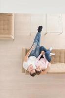 Young couple on the sofa watching television top view photo