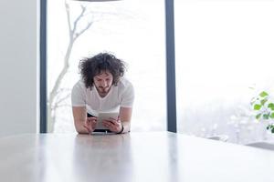 young man using a tablet at home photo