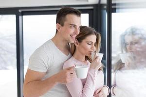 pareja joven disfrutando del café matutino junto a la ventana foto