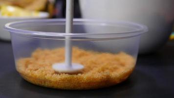 Closeup pressing cracker process in container for making banoffee, homemade bakery concept video