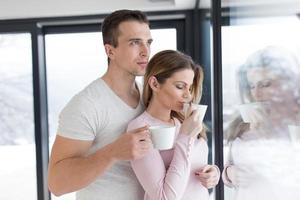 young couple enjoying morning coffee by the window photo