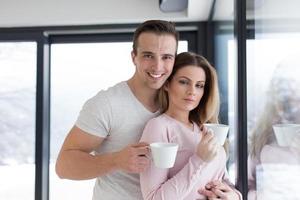 young couple enjoying morning coffee by the window photo