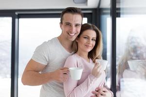 young couple enjoying morning coffee by the window photo