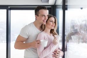 young couple enjoying morning coffee by the window photo