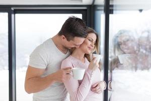 young couple enjoying morning coffee by the window photo