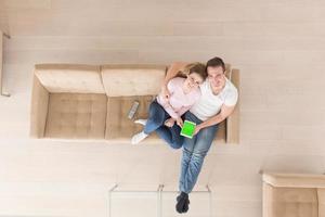 young couple in living room using tablet top view photo