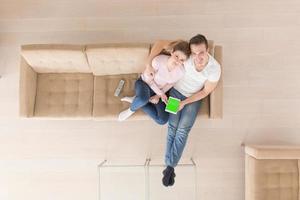 young couple in living room using tablet top view photo