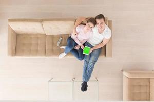 young couple in living room using tablet top view photo