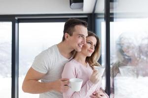 young couple enjoying morning coffee by the window photo