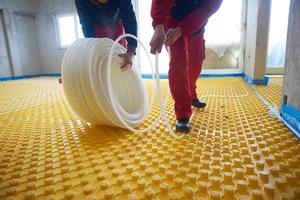 workers installing underfloor heating system photo