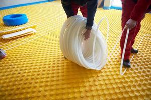 workers installing underfloor heating system photo