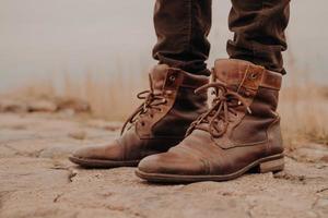 Image of mans legs in old boots. Concept of selling shoes. Autumn time. Horizontal view. Outdoor shot. Footwear photo