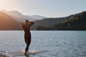 triathlon athlete starting swimming training on lake photo