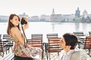 Outside photo of couple in love spend free time together, recreat at wonderful city with beautiful views, make photos on professional camera for remembering these pleasant moments. Tourism concept