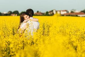 Passionate affectionate couple embrace each other, miss very much as havent seen for long time, spend wonderful summer day outdoor in yellow field. Romantic female and male hug with great love photo