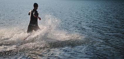 triathlon athlete starting swimming training on lake photo