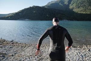 triathlon athlete starting swimming training on lake photo