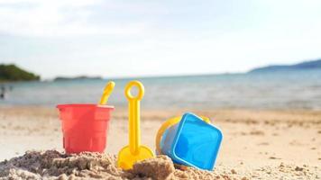 juguetes en la playa de arena con olas de mar seleccionar enfoque profundidad de campo con atmósfera de verano video