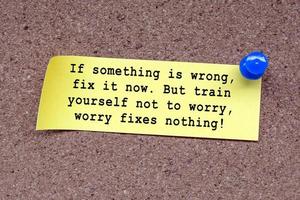 Motivational quote on stick note and pinned to a cork notice board. photo