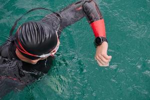 triathlon athlete swimming on lake setting smartwatch photo