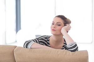 portrait of a young beautiful woman sitting on the sofa photo