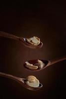 Pickled Boletus mushrooms on wooden spoons on dark background. photo