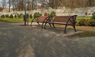 Empty benches near the path in the Park. Ban on walking due to threat of coronavirus. photo