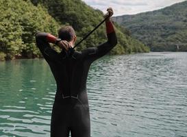 triathlon athlete getting ready for swimming training on lake photo