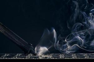 Backdrop of smoking soldering iron on dark background. photo