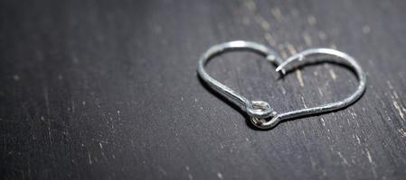 Heart-shaped fish hooks on a dark background. photo