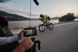 cinematographer taking action shot of triathlon bike athlete photo