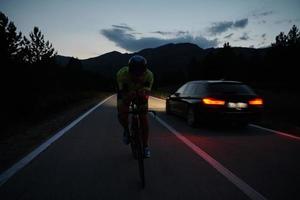 triathlon athlete riding bike at night photo