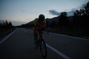 triathlon athlete riding bike at night photo