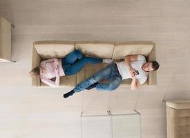 couple on sofa using mobile phones top view photo