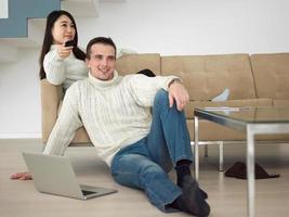 multiethnic couple on the sofa watching television photo