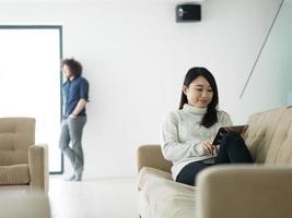 pareja multiétnica en casa usando tabletas foto