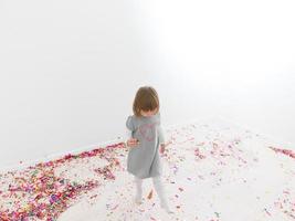 Little girl standing on confetti photo