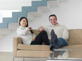 multiethnic couple on the sofa watching television photo